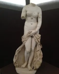 Venus Landolina, a headless white marble female statue with a missing right arm, holding drapery over her lower body.