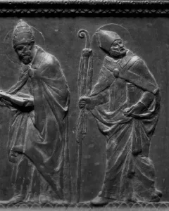 Relief panel from Donatello\'s Door of the Apostles showing two robed haloed figures, one holding a book and the other a staff.