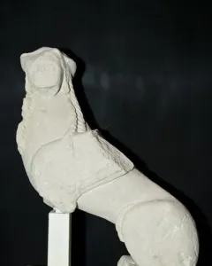 Sphinx of Agost stone sculpture with a human head, wings, and an animal body on a base.