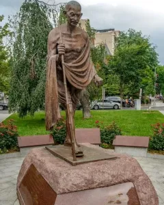 Mahatma Gandhi Memorial bronze sculpture of Gandhi walking with a staff on a stone pedestal.