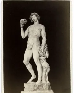 Michelangelo’s Bacchus, a marble statue of a nude male figure holding a goblet and grapes with a small satyr beside him.