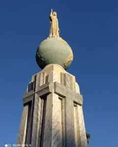 Divino Salvador del Mundo statue of Jesus standing on a globe against a blue sky