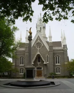 Seagull Monument in front of the Assembly Hall, with a golden bird statue atop a tall column and a stone building behind it.