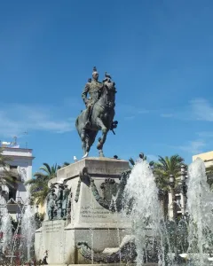 Bronze equestrian monument to Primo de Rivera on a tall stone pedestal, with fountains spraying around the base.
