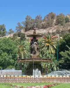 Three Graces Fountain with classical female figures and flowing water in a park