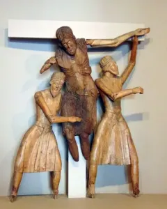 Wooden Descent from the Cross sculpture with a central figure being lowered from a beam by two robed figures, flanked by two crucified figures.
