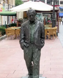 Woody Allen Memorial sculpture of a man in spectacles, jacket, and loose trousers standing with hands in pockets.