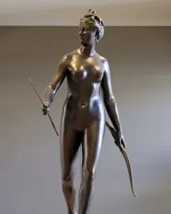 Bronze statue of Diana holding a bow and arrow in a twisting pose.