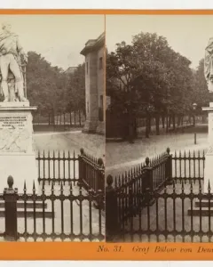 Stereoscopic card showing the Bülow Monument in Berlin, with the statue on a pedestal behind a low fence.