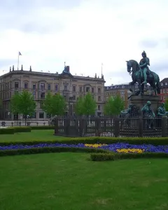 Christian V equestrian statue showing an armored rider on a rearing horse atop an ornate pedestal with sculptural figures.