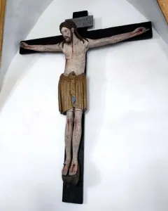 Enghausen Cross showing a painted wooden crucifix with Christ on a dark cross and a plaque above his head.