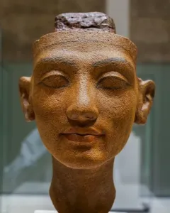 Unfinished head of Nefertiti with closed eyes and a rough top edge.