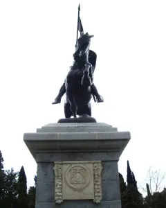 El Cid sculpture of a rider on a rearing horse atop a tiered stone pedestal.