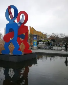 Keith Haring\'s The Boxers sculpture with two brightly colored figures standing in a shallow pool at Potsdamer Platz, Berlin.