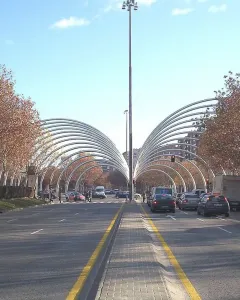 Puerta de la Ilustración spans a Madrid avenue with curved metallic arches over the road and a tall central light pole.