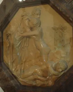 Creation of Eve terracotta relief showing a draped figure embracing a smaller nude figure above a reclining nude figure.