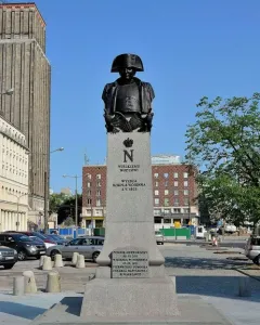 Napoleon Bonaparte monument in Warsaw, showing a bronze bust on a tall stone plinth.