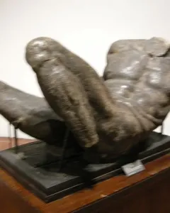 River God sculpture showing a large muscular male torso lying horizontally on a dark base.