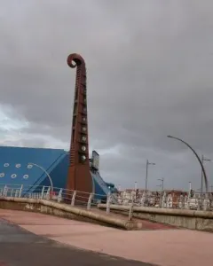 The Blackpool High Tide Organ sculpture beside a blue building on a paved promenade.