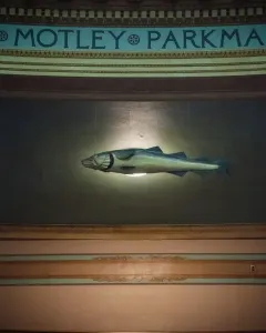 The Sacred Cod sculpture suspended between ornate pillars in the Massachusetts State House chamber.