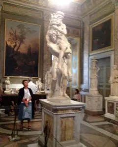 A marble sculpture of Aeneas, Anchises and Ascanius showing a man carrying an older man while a child clings to his leg.