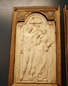 Queriniano Diptych ivory relief panel with a male and draped female figure under an arch, flanked by columns and a small winged figure.
