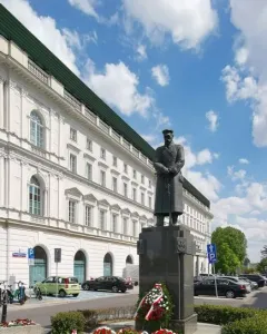 Józef Piłsudski Monument on a dark granite pedestal with red and white wreaths at its base.