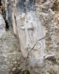 Bas-relief carvings on the rock face at Yazılıkaya, with stylized figures carved into a smoother section of stone.