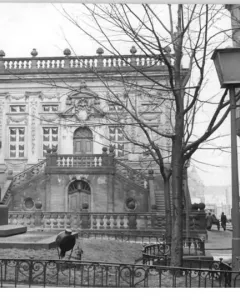 Goethe Monument stands on a tall pedestal in front of an ornate building in Leipzig.