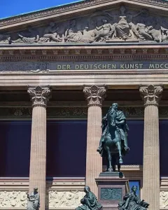 Frederick William IV equestrian statue in front of a classical building with columns and a sculpted frieze.