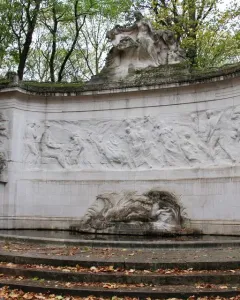Monument to the Belgian Pioneers in Congo with a curved stone frieze and sculpted figures above a shallow pool