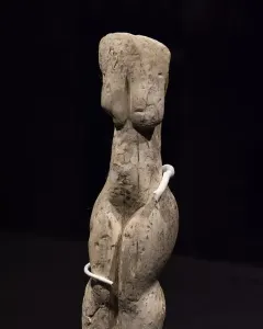 Venus of Eliseevichi ivory figurine on a mount against a dark background