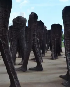 Agora sculpture with numerous dark headless human figures standing together in Grant Park