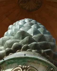 La Pigna sculpture resembling a giant green pine cone in front of a domed building