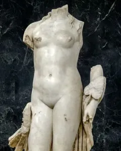 Venus Unica, a headless white stone female nude statue on a rectangular base.
