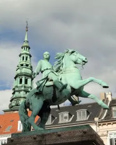 Absalon Monument, a green equestrian statue on a stone pedestal with a tall spire in the background.