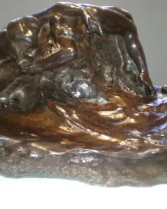 Illusions Received by the Earth, a dark bronze sculpture of two intertwined nude bodies melting into a rocky base.