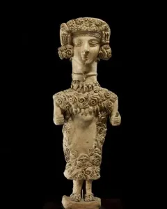 Lady of Ibiza clay figure with an elaborate headdress and intricate scrollwork patterns