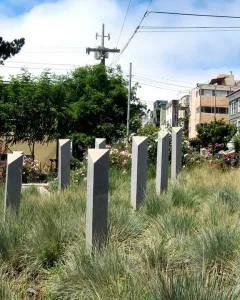 Pink Triangle Park memorial columns with triangular caps among tall grasses