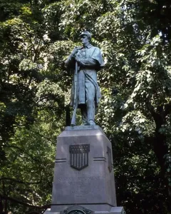 Seventh Regiment Memorial statue of a soldier holding a rifle beside a stone pedestal in Central Park