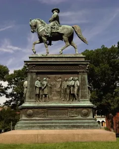 The Major General John A. Logan bronze equestrian statue on a tall pedestal in a park, with trees and buildings in the background.