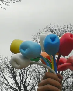 Bouquet of Tulips sculpture showing a giant hand holding colorful tulip-like forms against an overcast sky.