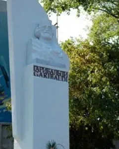 Garibaldi Monument with a bearded bust and floral tribute at the base