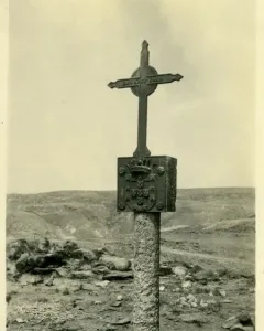 The Padrão de Santa Maria stone pillar with a crowned shield and cross on top, standing in a barren landscape.