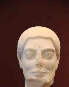Sabouroff Head marble bust of a male figure with textured hair, mustache, and beard on a stand.
