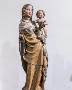 Friesentor Madonna, a weathered painted wooden sculpture of the Madonna holding the infant Jesus on her hip.