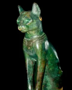 Gayer-Anderson Cat statue with a gold nose ring, earring, and decorated collar.
