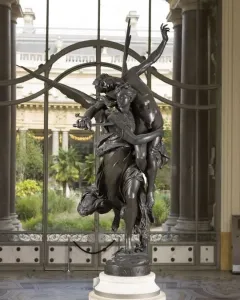 Gloria Victis bronze sculpture of a winged female figure carrying a fallen male warrior on a pedestal.
