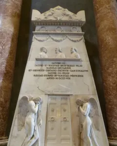 Monument to the Royal Stuarts with white marble figures, busts, and a Latin inscription between red marble columns