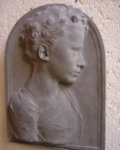 Bust of a Child in gray stone, shown in profile with curly hair and draped shoulders.